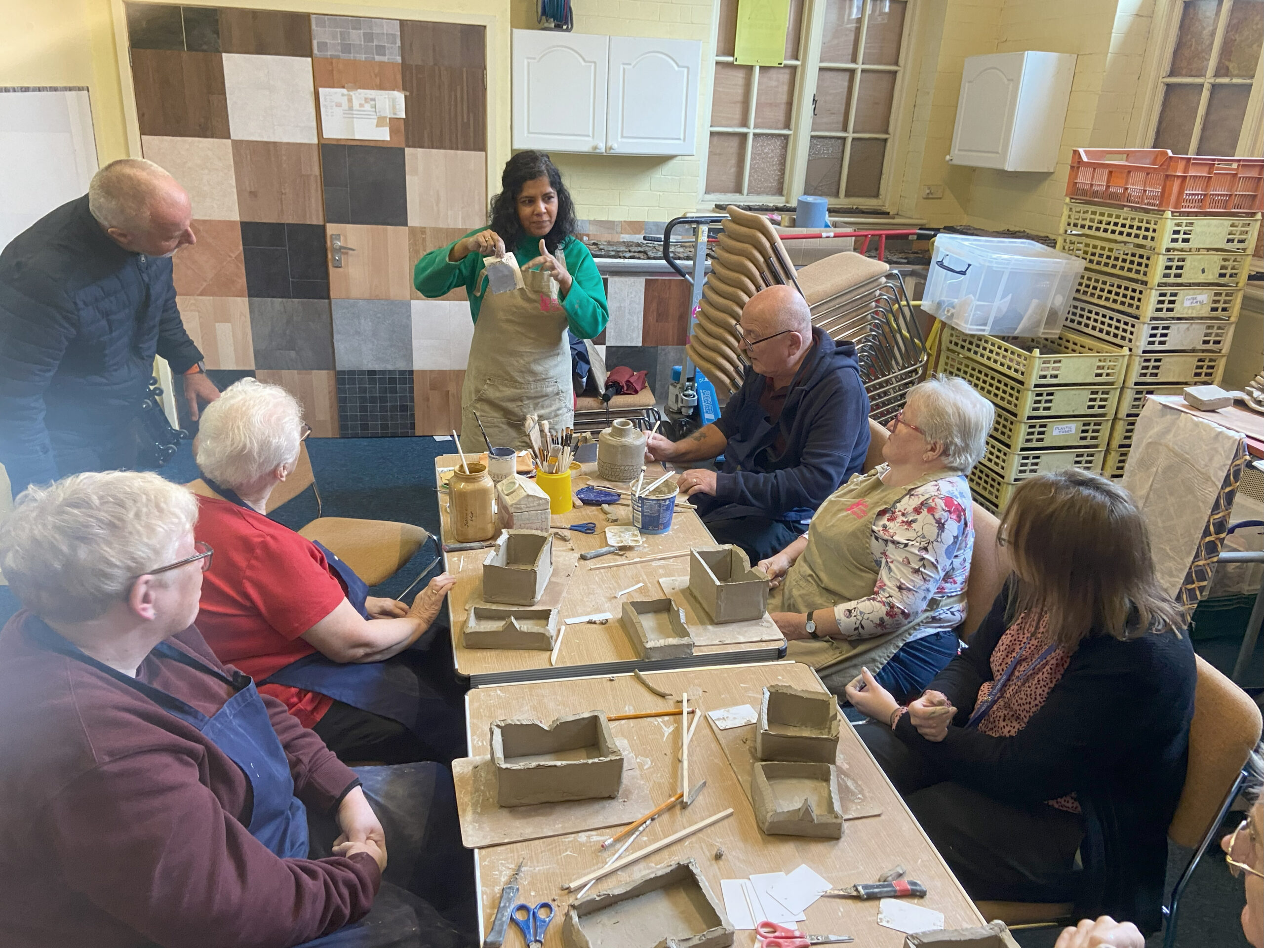 People sitting at a table taking part in a ceramics workshop