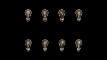 A set of lightbulbs arranged in rows in the dark