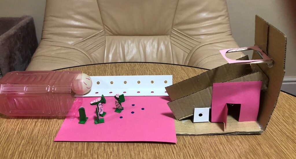 A pink paper game on a brown wood table