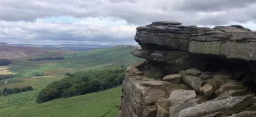 Photograph of a peak district landscape with a rocky outcrop to the right